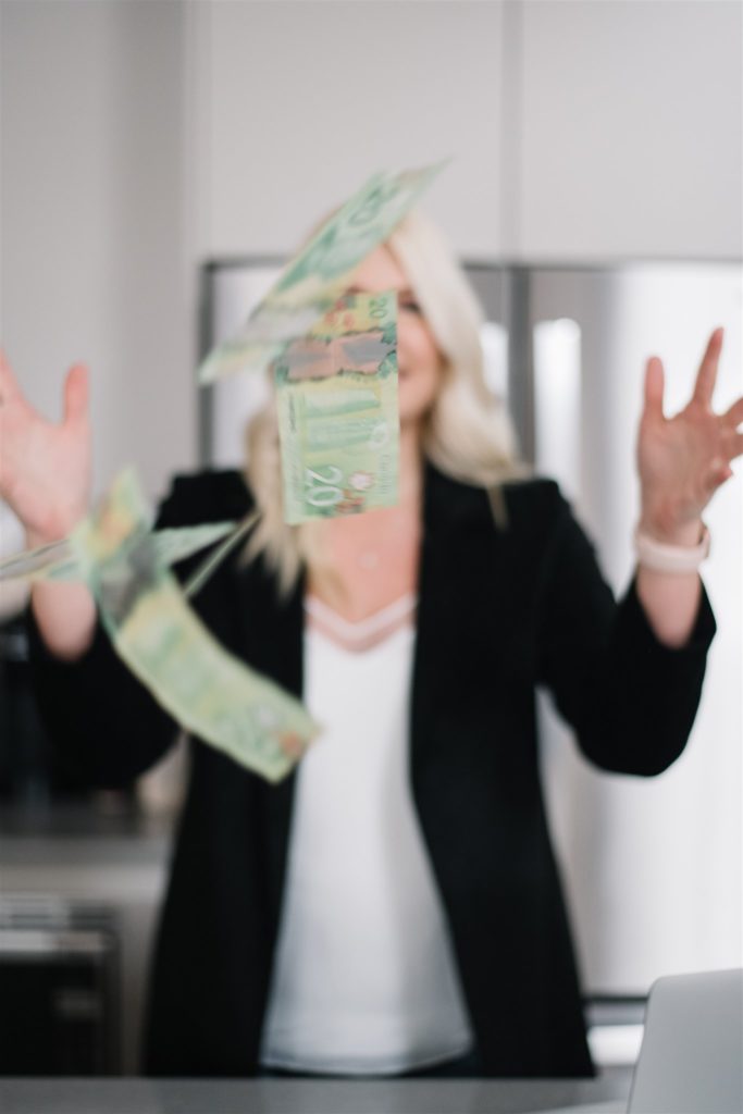 Blonde woman out of focus throwing money in the air