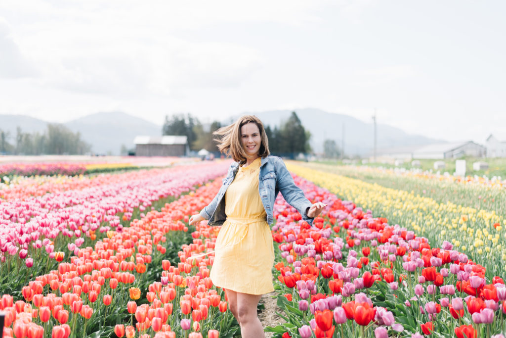 woman spinning in a field of brightly coloured tulips