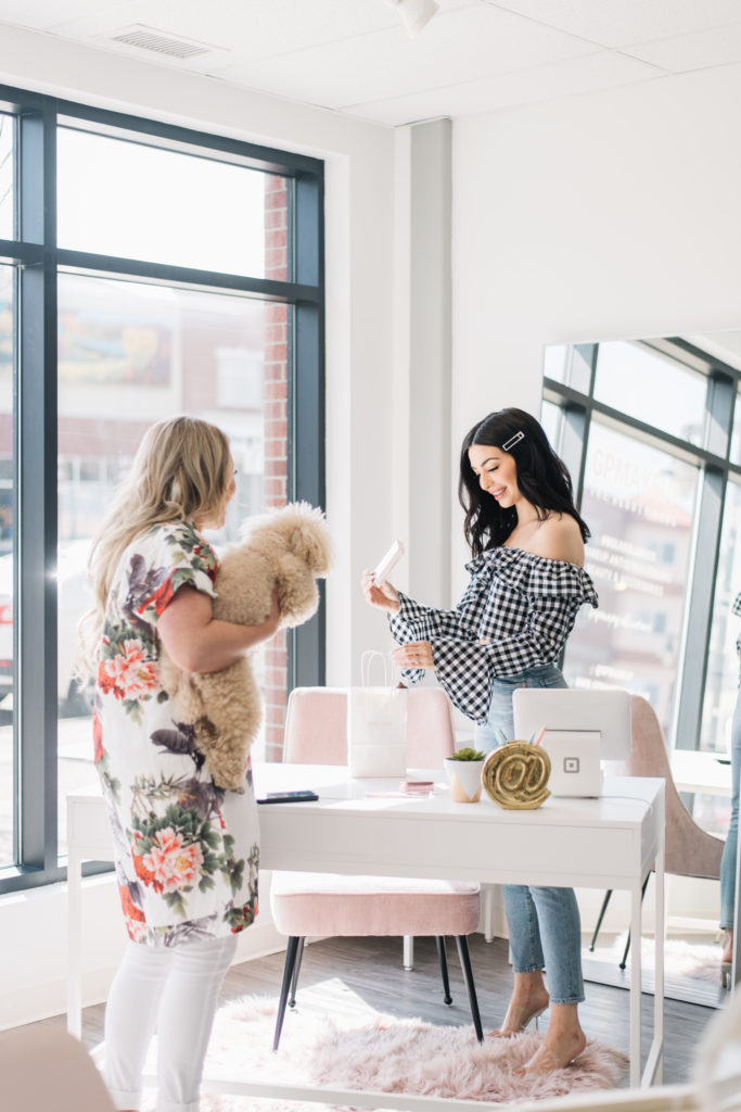woman smiling as she places products into a bag