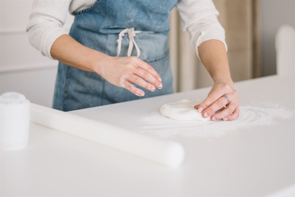 woman rolling out fondant during a branding session