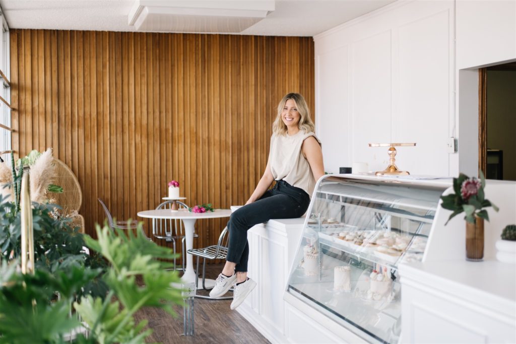 woman sitting on counter in cake shop