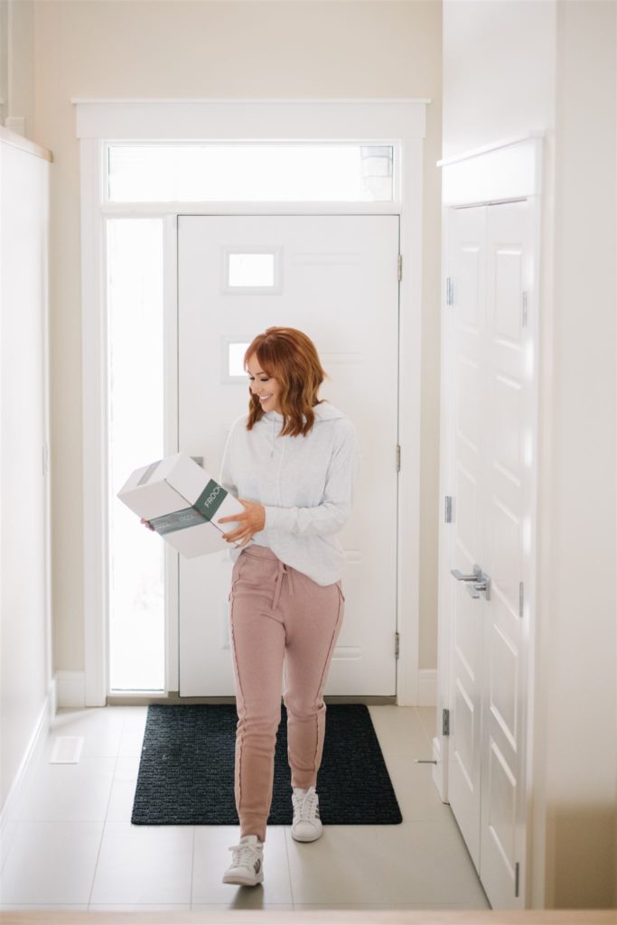 Woman walking inside her home after receiving a package 