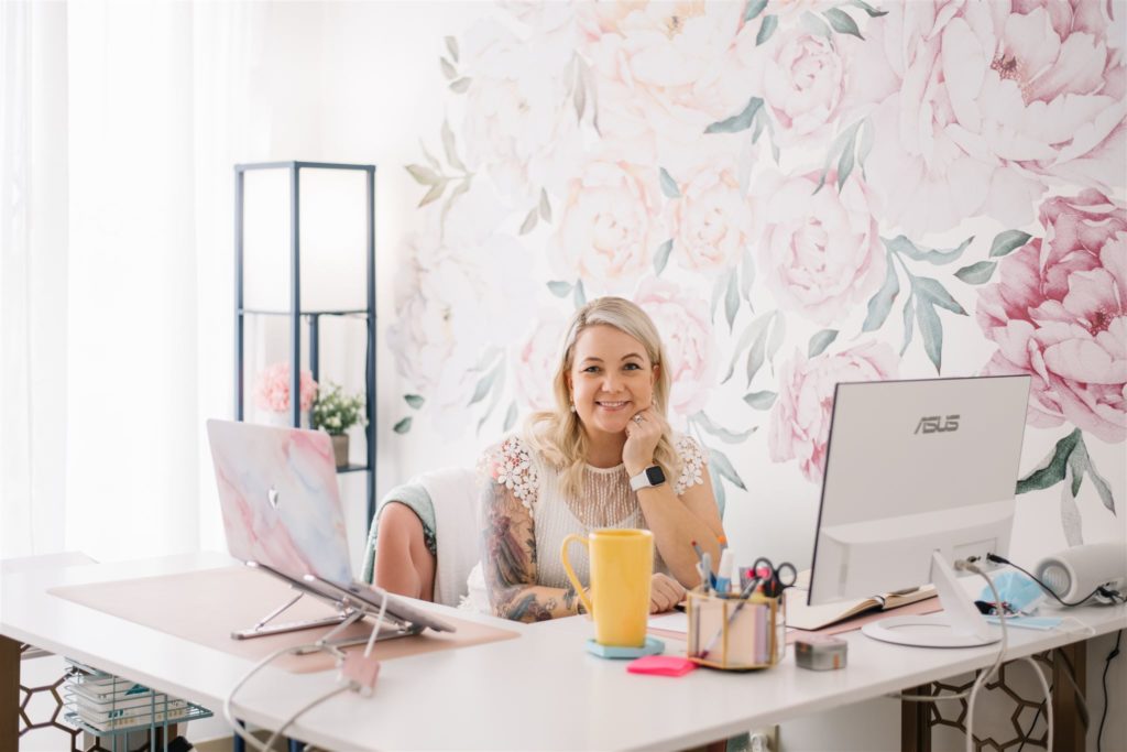 woman sitting behind her desk smiling