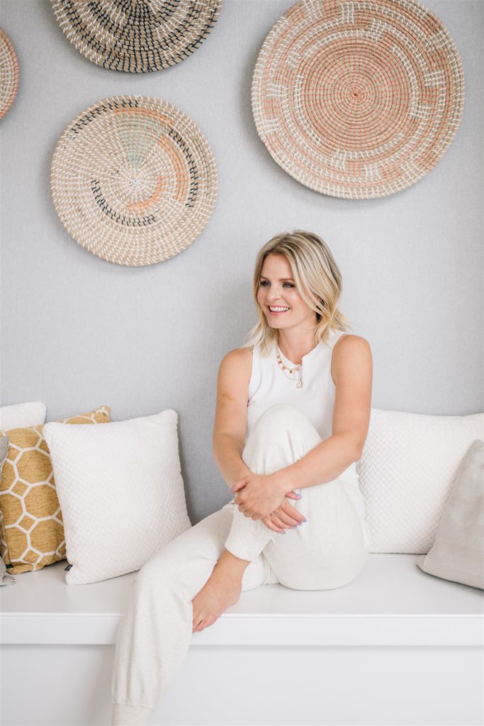 Woman sitting on a ledge with white pillows